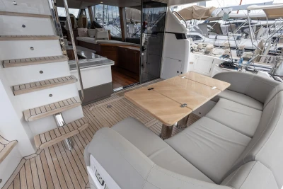 Luxurious 2023 Princess F55 yacht interior with elegant seating and wooden table.