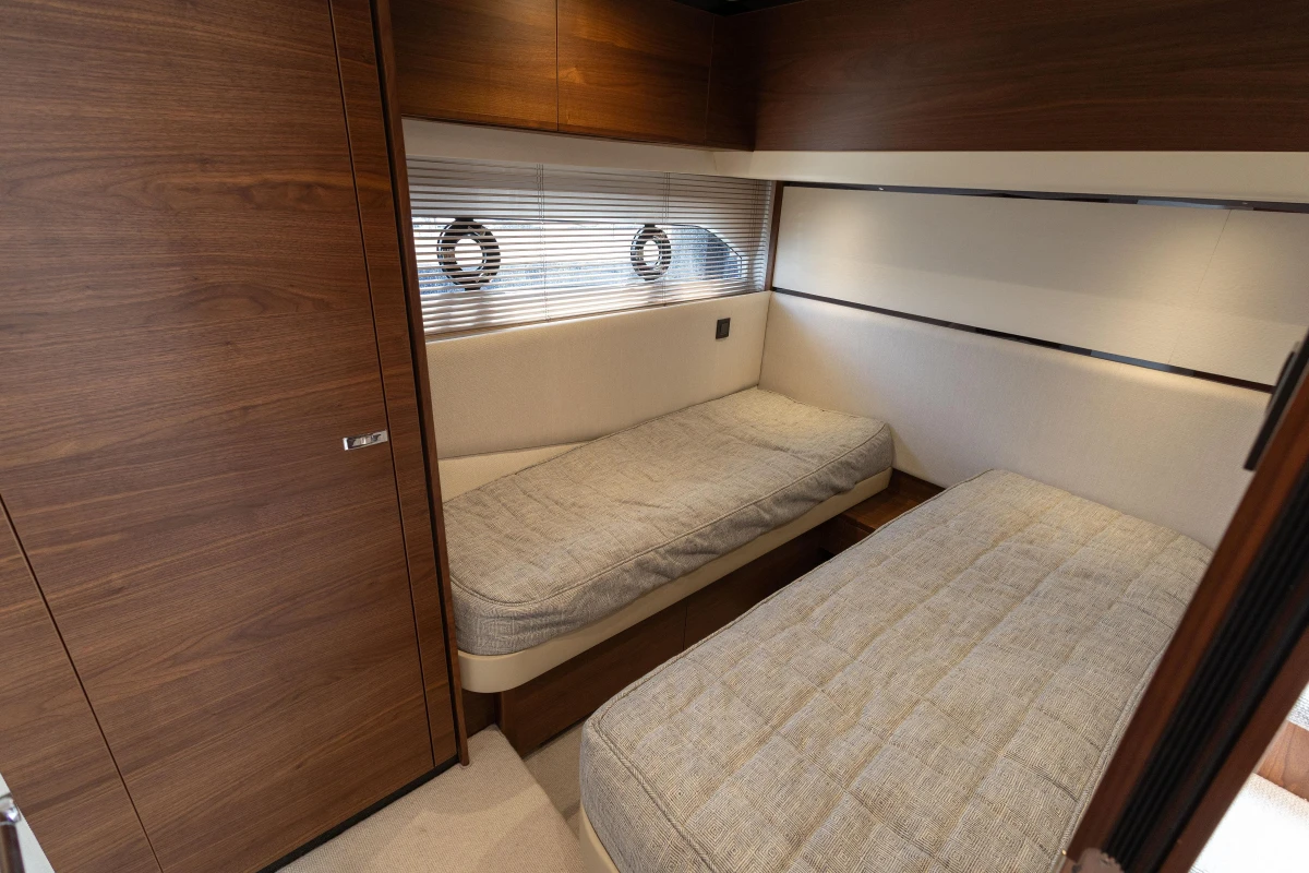 Luxurious cabin interior of 2023 Princess F55 yacht with twin beds and wooden finishes.