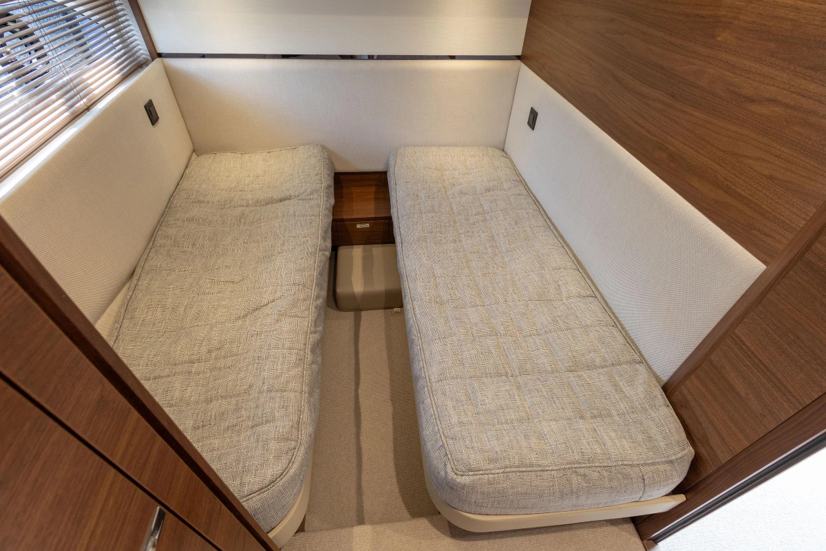 2023 Princess F55 yacht interior with twin beds and wooden accents.