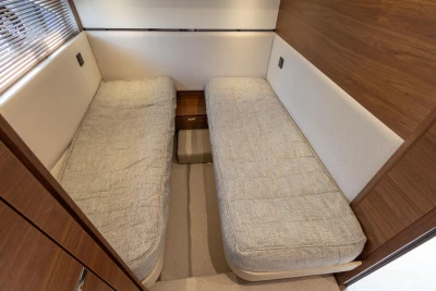 2023 Princess F55 yacht interior with twin beds and wooden accents.