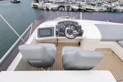 Flybridge of 2014 Princess 56 yacht with helm station and marina view.