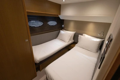 Twin cabin in 2014 Princess 56 yacht with modern decor and cozy bedding.