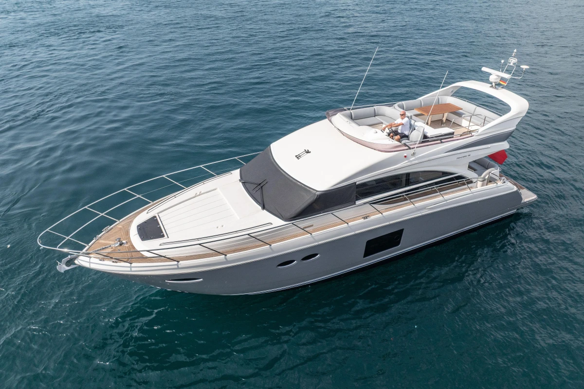 Luxurious 2014 Princess 56 yacht cruising on open water, featuring sleek design and spacious deck.