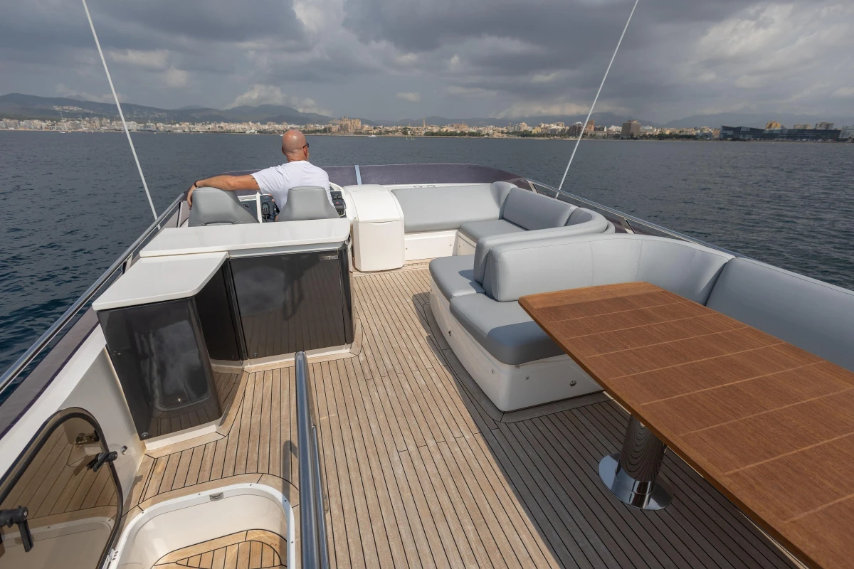 Luxurious 2014 Princess 56 yacht deck with seating and table, cruising on calm waters.