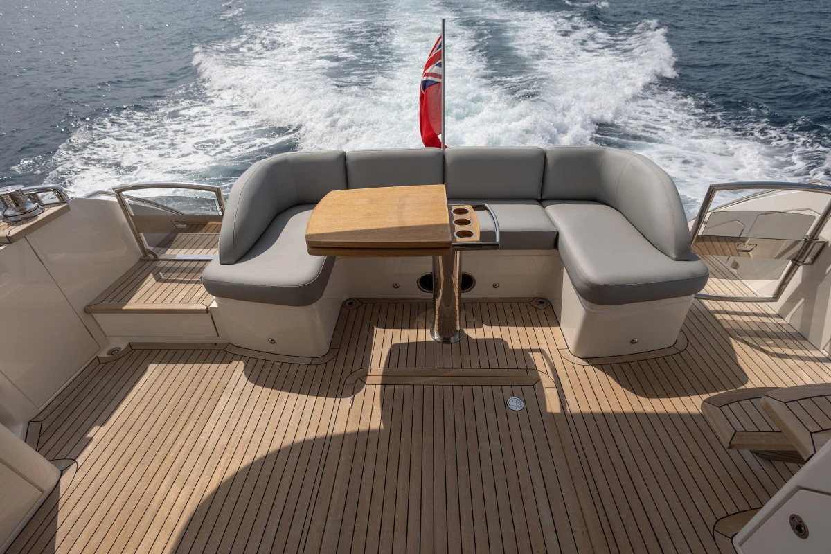 Luxurious 2014 Princess 56 yacht deck with seating and table, cruising on open water.