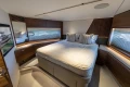 Luxurious bedroom interior of 2026 Princess Y72 yacht, featuring elegant wood finishes and plush bedding.