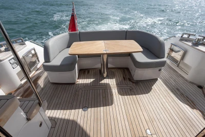 Luxury seating area on 2023 Princess F50 yacht with wooden deck and ocean view.