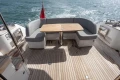 Luxury seating area on 2023 Princess F50 yacht with wooden deck and ocean view.