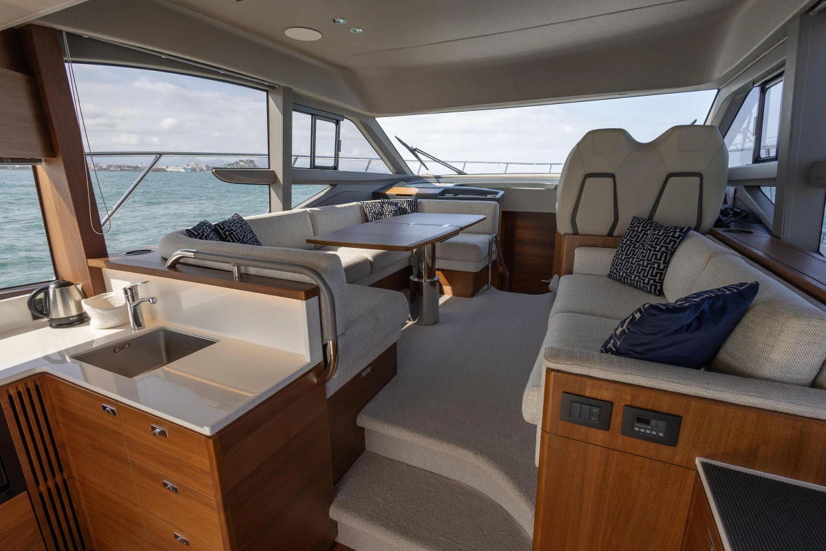 Luxurious interior of 2023 Princess F50 yacht with modern seating and kitchenette.