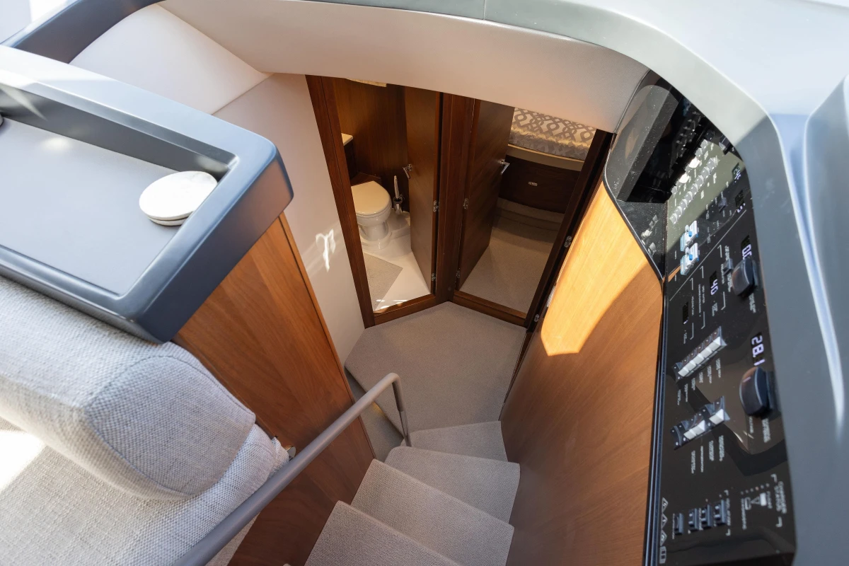 Interior of 2023 Princess F50 yacht showing stairs, control panel, and bathroom entrance.