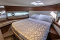 Luxurious bedroom interior of 2023 Princess F50 yacht with elegant bedding and wood accents.