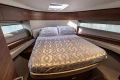 Luxurious bedroom interior of 2023 Princess F50 yacht with elegant bedding and wood accents.