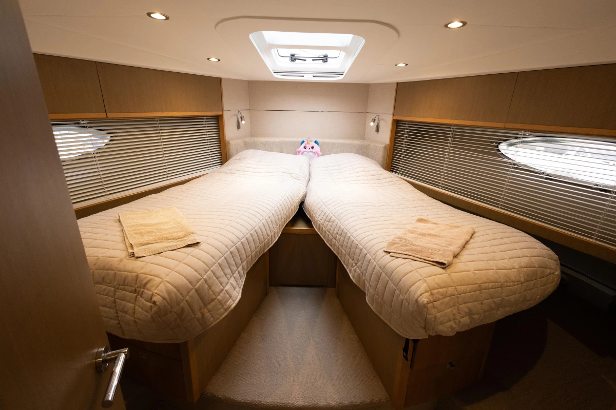 Luxurious 2014 Princess V52 yacht cabin with twin beds and modern lighting.
