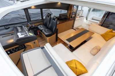 Luxurious interior of 2014 Princess V52 yacht with leather seating and modern helm.
