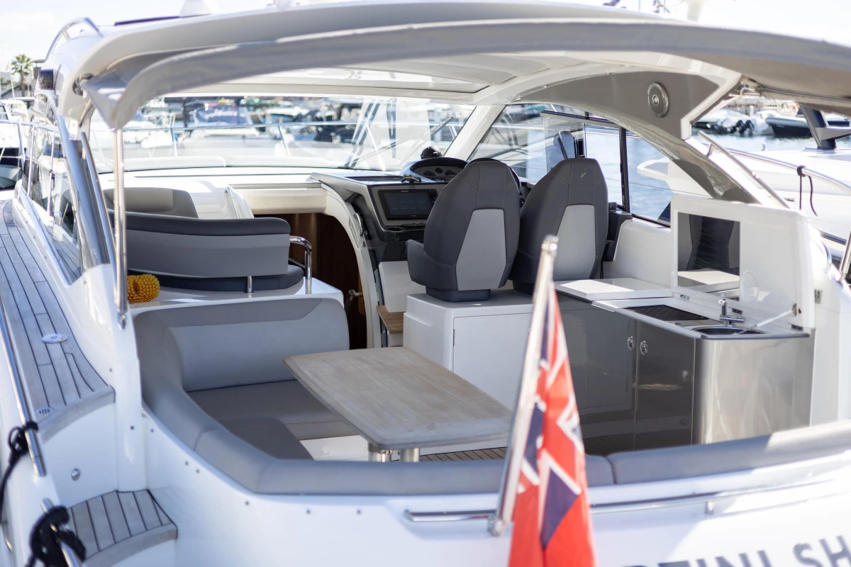 2017 Princess V40 yacht interior with seating, table, and helm, docked at marina.