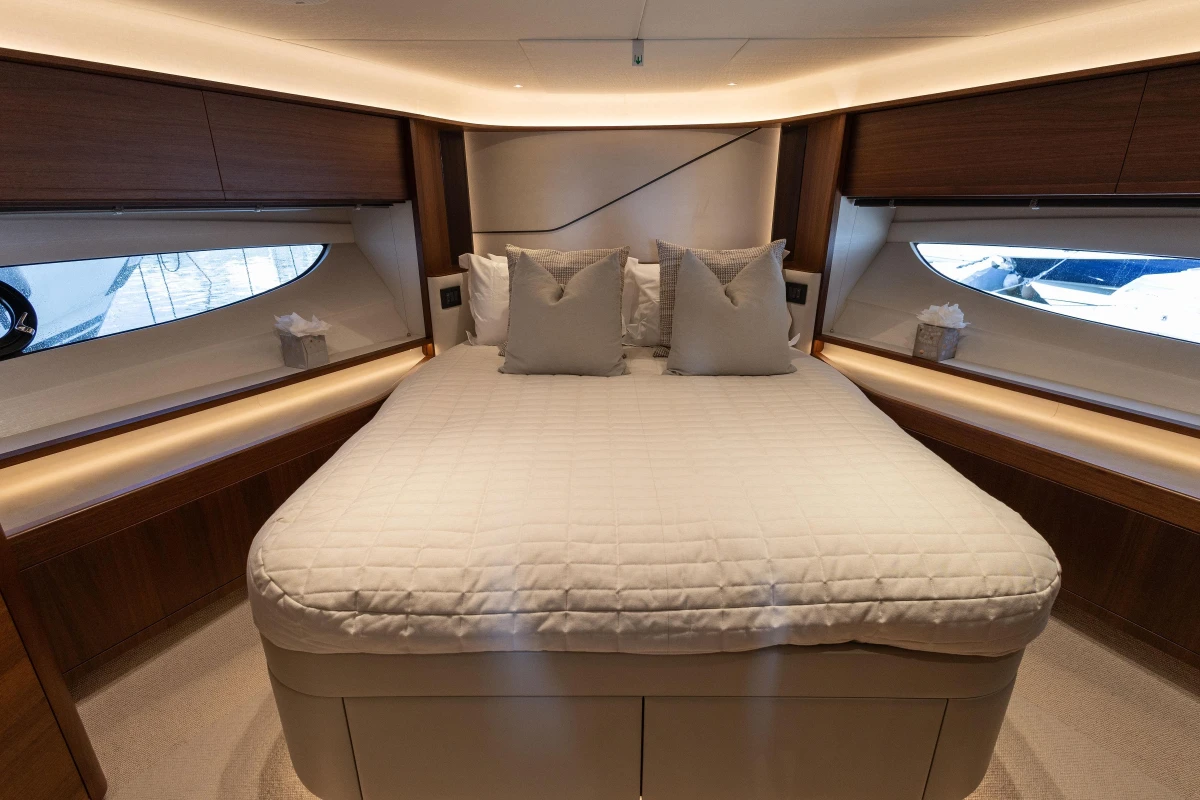 Luxurious bedroom interior of 2022 Princess S78 yacht with elegant wood finishes.