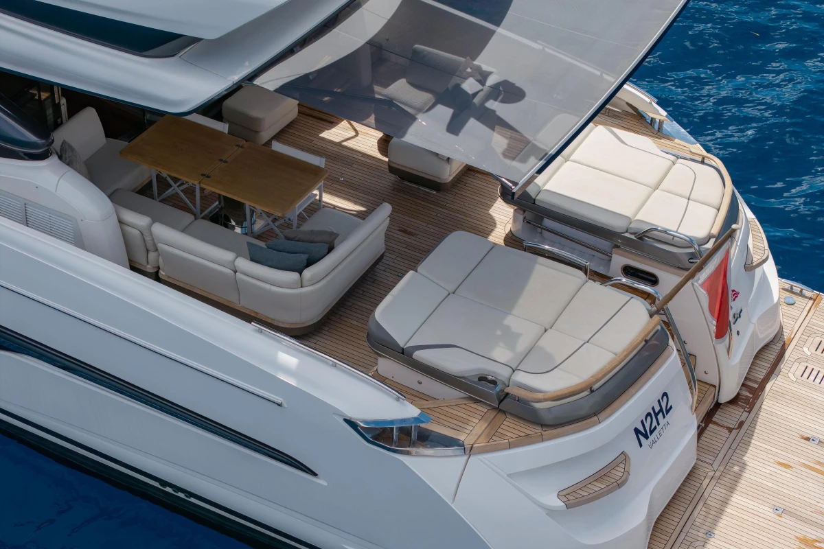 Luxurious 2022 Princess S78 yacht deck with seating and dining area on blue water.