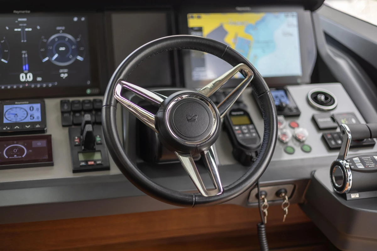 Steering wheel and control panel of 2022 Princess S78 yacht cockpit.