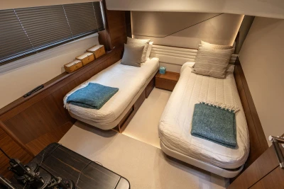 Luxurious 2022 Princess S78 yacht cabin with twin beds and elegant decor.