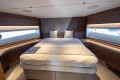 Luxurious 2023 Princess S72 yacht bedroom with elegant wood accents and large windows.