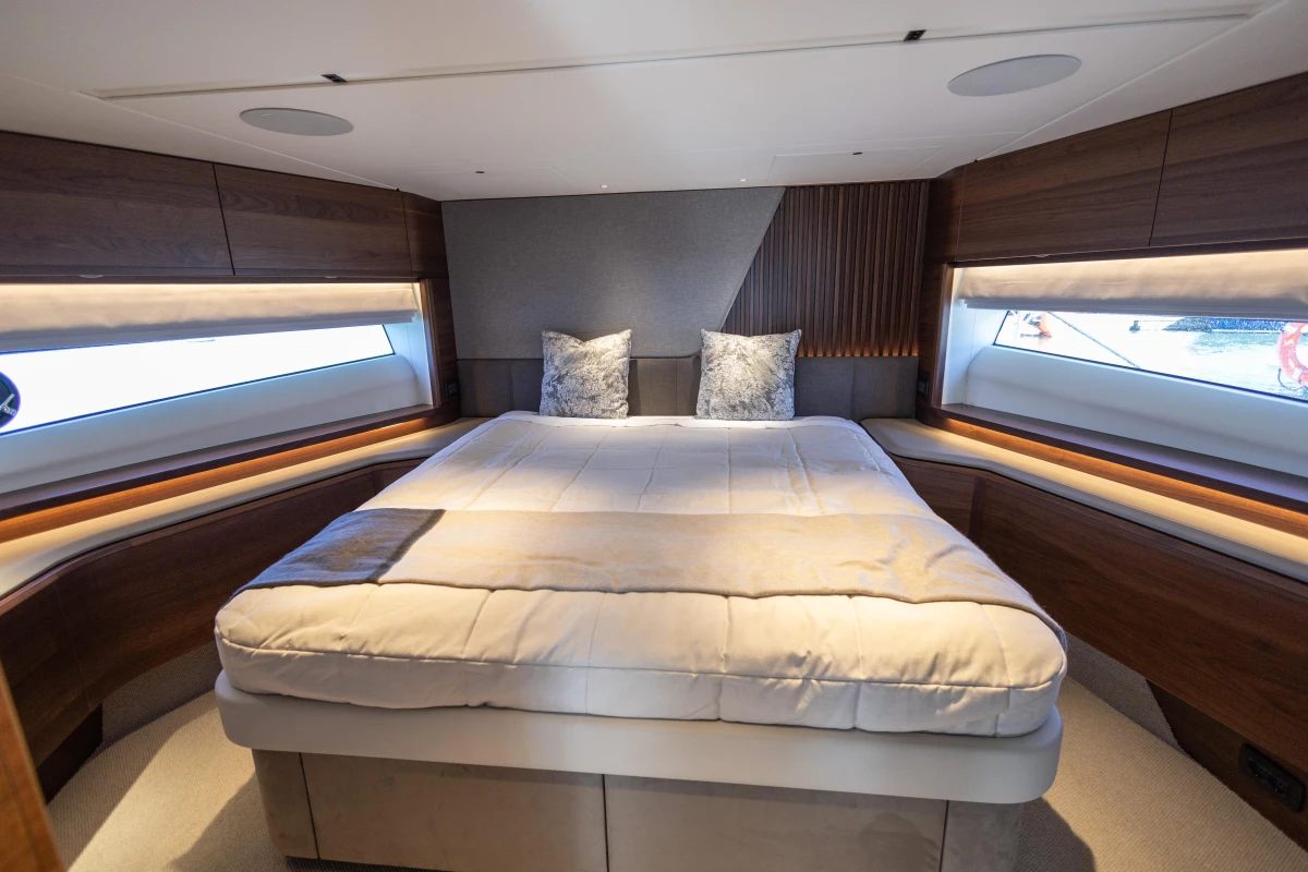 Luxurious 2023 Princess S72 yacht bedroom with elegant wood accents and large windows.