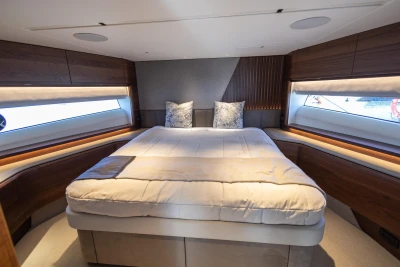Luxurious 2023 Princess S72 yacht bedroom with elegant wood accents and large windows.