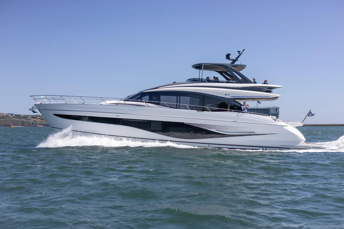 2023 Princess S72 yacht cruising on open water under clear blue skies.