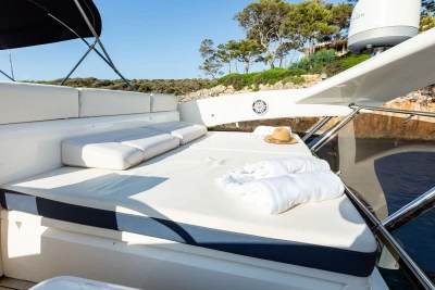 Luxurious sun deck on a 2008 Princess 58 yacht with cushions and towels.