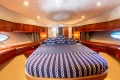 Luxurious 2008 Princess 58 yacht bedroom with elegant wood finish and nautical-themed bedding.