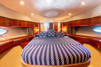 Luxurious 2008 Princess 58 yacht bedroom with elegant wood finish and nautical-themed bedding.