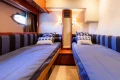 Twin cabin with striped bedding in 2008 Princess 58 yacht interior.