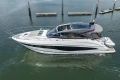 2023 Princess V50 yacht cruising on calm waters near a dock.
