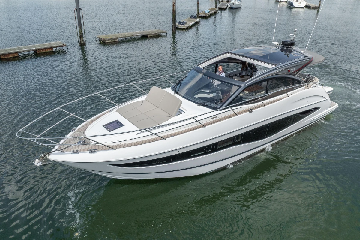 2023 Princess V50 yacht cruising in a marina, showcasing sleek design and luxury features.