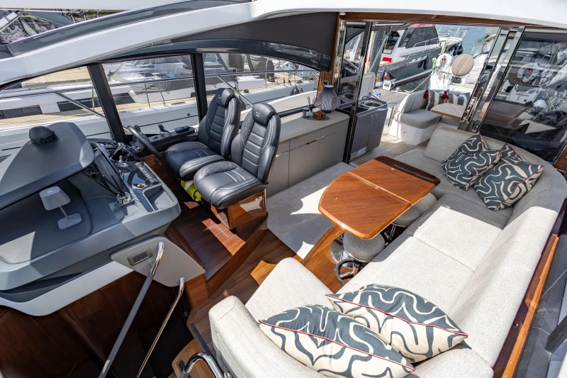Luxurious interior of 2023 Princess V50 yacht with plush seating and modern helm.