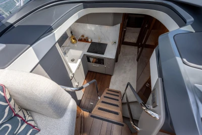 Modern kitchen interior on 2023 Princess V50 yacht, featuring sleek design and wooden flooring.