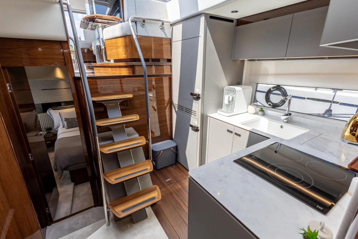 Luxurious interior of 2023 Princess V50 yacht with modern kitchen and stylish staircase.