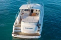 2006 Princess V53 yacht on calm blue water, rear view with deck seating.
