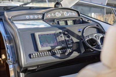 Control panel of a 2006 Princess V53 yacht with navigation equipment and steering wheel.