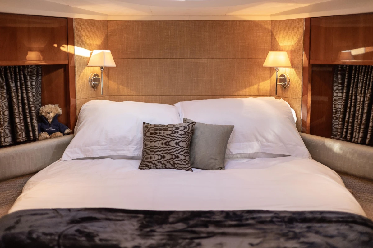Luxurious bedroom interior of 2006 Princess V53 yacht with elegant bedding and soft lighting.
