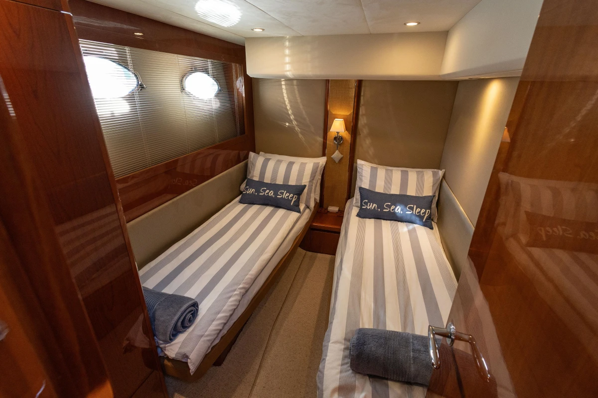 Luxurious 2006 Princess V53 yacht cabin with twin beds and nautical decor.