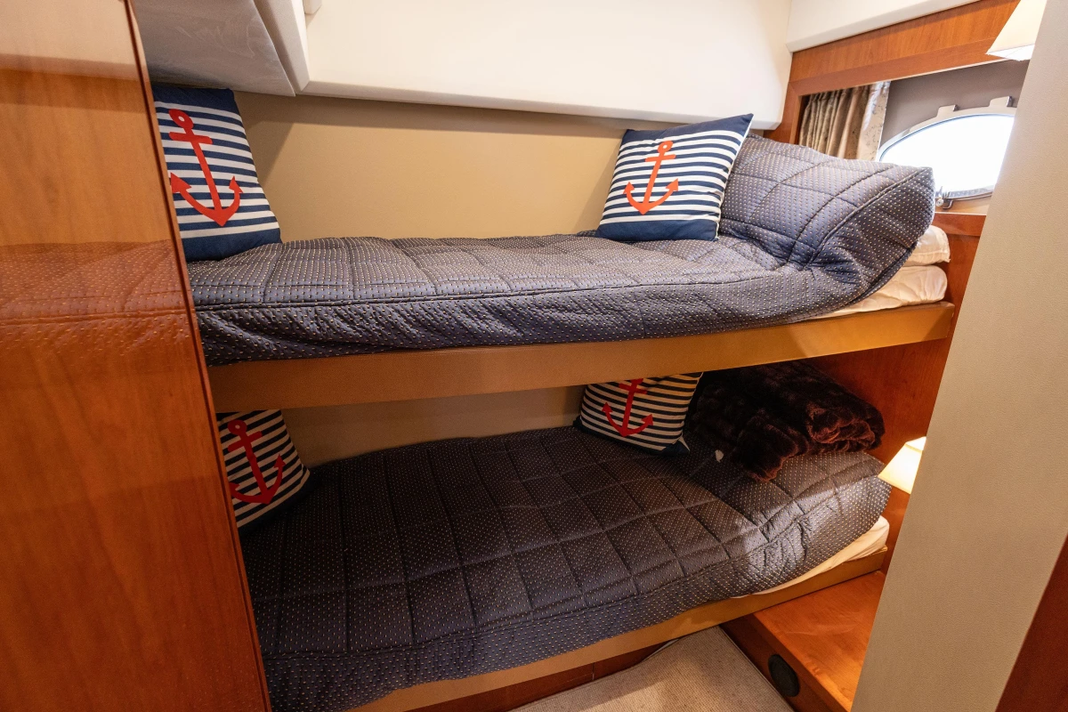 Cozy bunk beds with nautical-themed pillows in a 2006 Princess V53 yacht cabin.