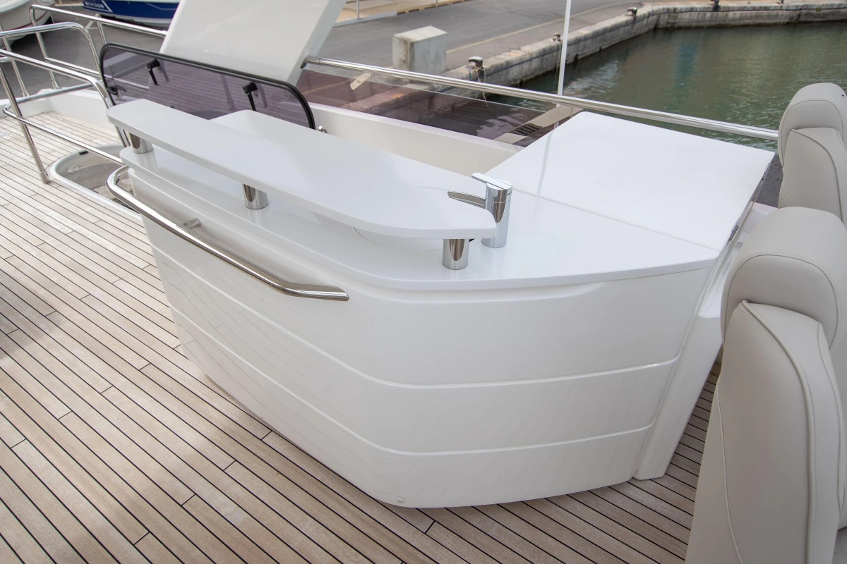 Luxurious 2015 Princess 68 yacht deck with sleek white bar and modern seating.