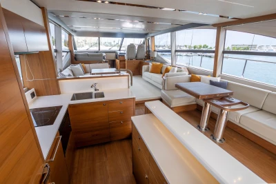 Luxurious interior of 2015 Princess 68 yacht with modern kitchen and spacious seating area.