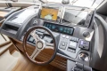 Control panel of a 2015 Princess 68 yacht with navigation screens and steering wheel.
