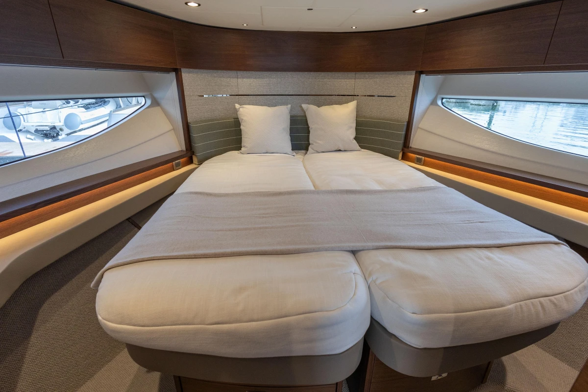 Luxurious interior of 2025 Princess V55 yacht with elegant bedding and panoramic windows.