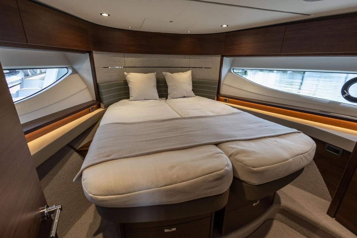 Luxurious interior cabin of 2025 Princess V55 yacht with elegant bedding and modern design.