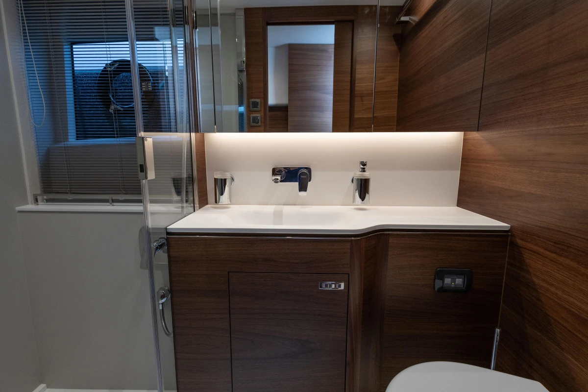 Luxurious bathroom interior of 2025 Princess V55 yacht with modern wood finish.