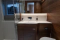 Luxurious bathroom interior of 2025 Princess V55 yacht with modern wood finish.