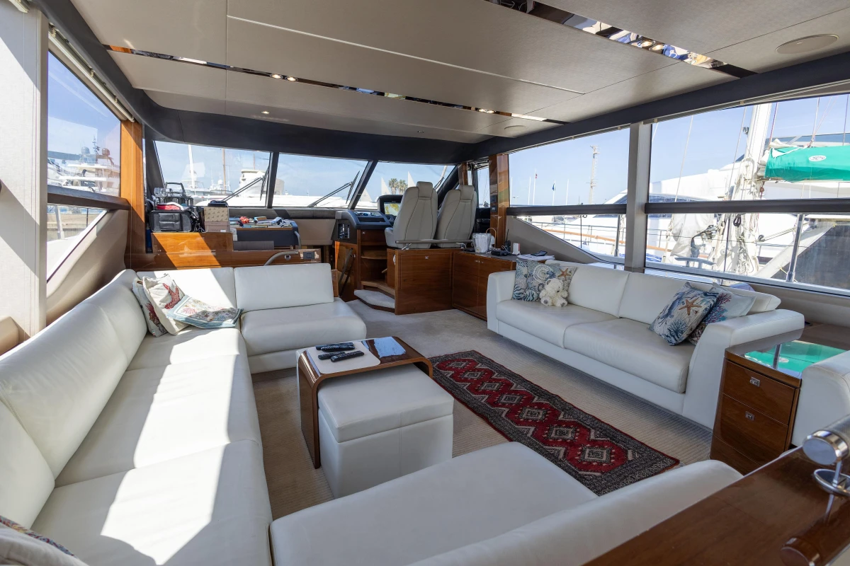 Luxurious interior of a 2017 Princess 68 yacht with elegant white seating and panoramic windows.