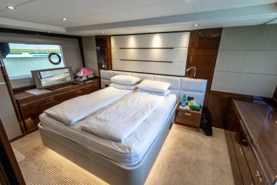Luxurious bedroom interior on a 2017 Princess 68 yacht, featuring elegant wood finishes.